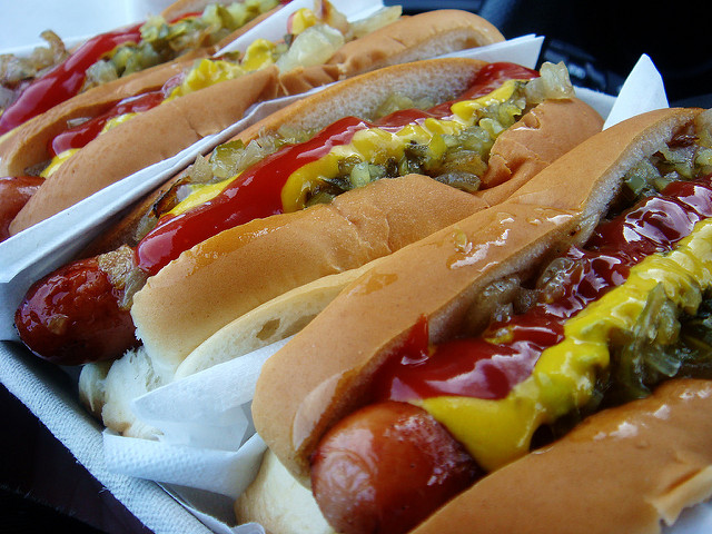 Three Hot Dogs loaded with condiments.